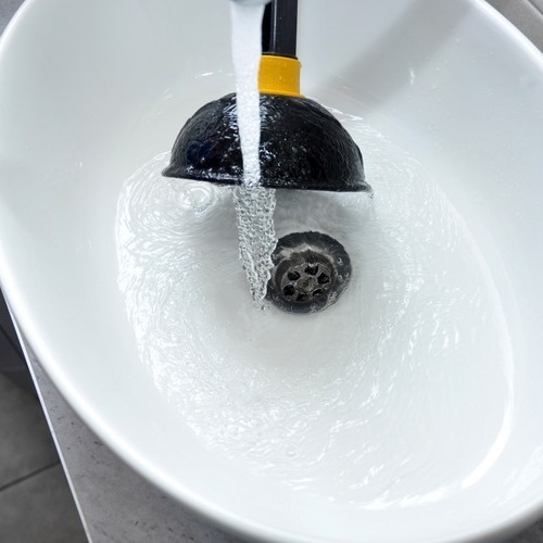 A sink with water running in it and a toothbrush